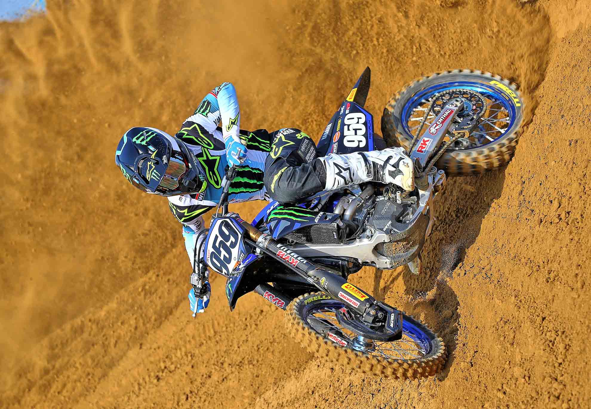 il pilota monster energy yamaha factory MXGP maxime renaux che guida la sua moto nella pista professional di motocross dorno derapando in curva ed alzando un muro di terra dietro di se